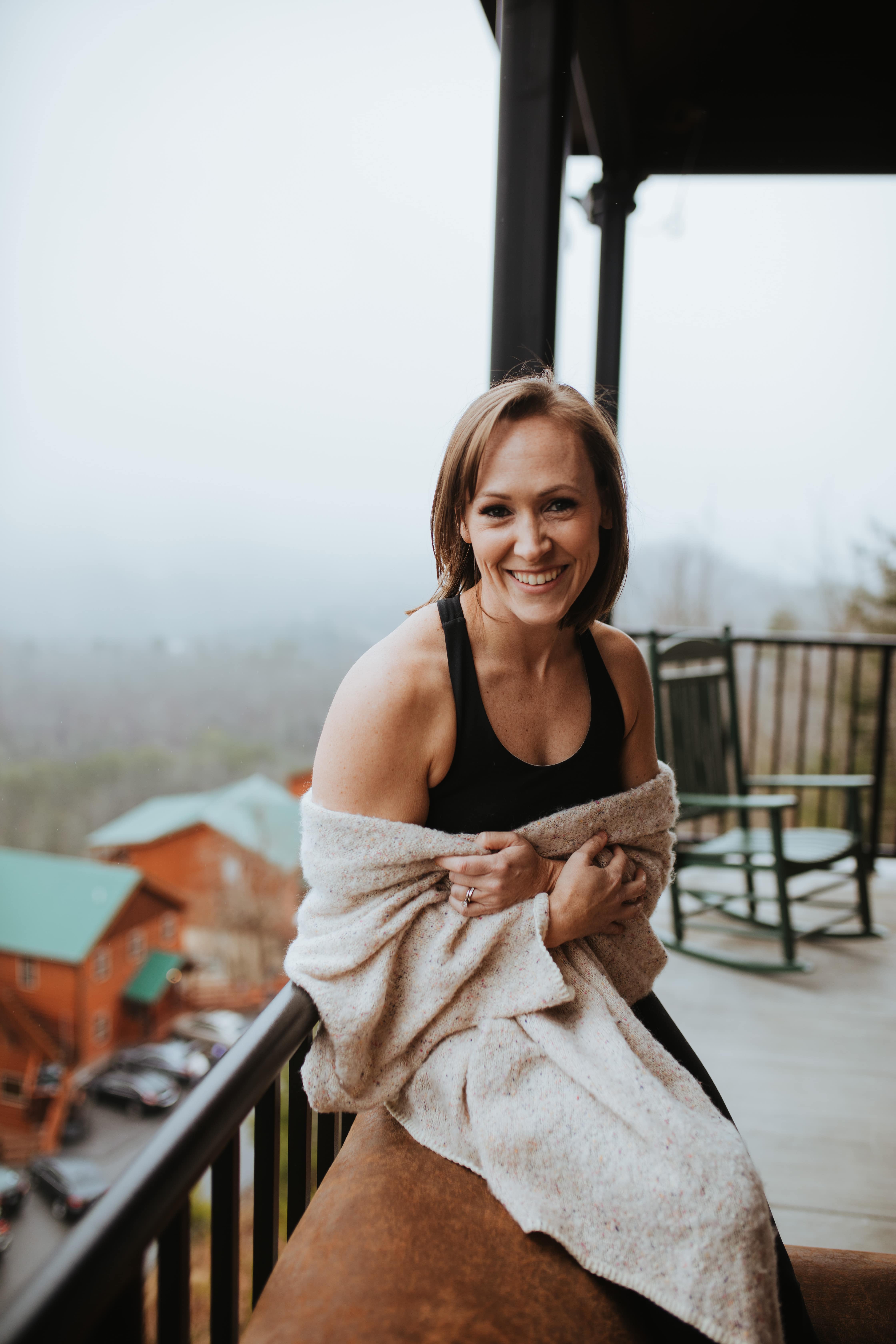 MK sitting on the porch wrapped in a throw blanket