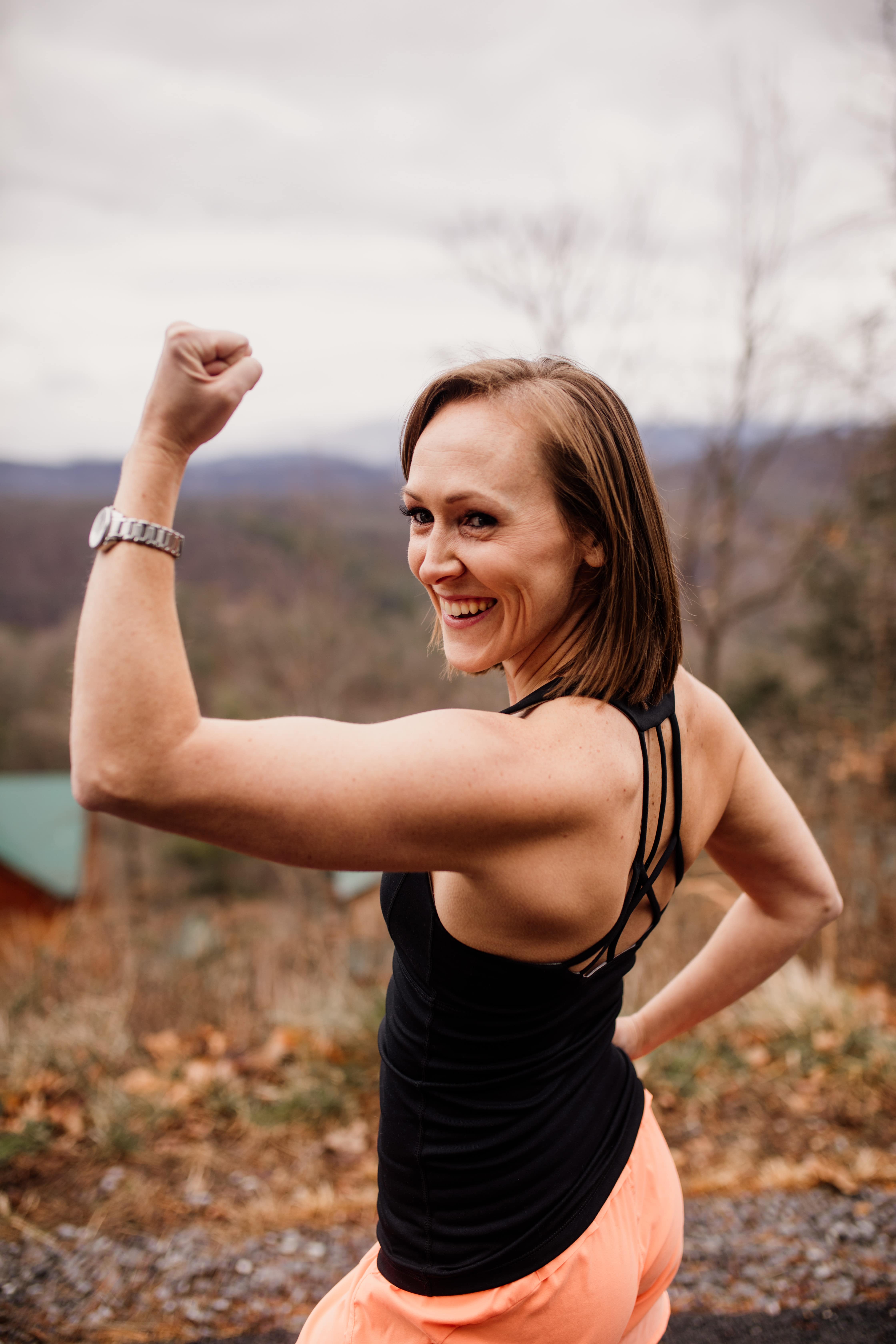 MK flexing her bicep and smiling